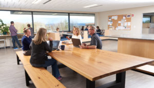 staff sits, smiling at an open concept office cafeteria at Vermont Information Processing