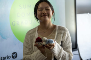 A Summer Company student holding their crochet created product. 