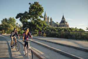 Cyclists bike along near the Parliament Buildings in Ottawa.