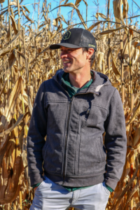 Alain Goubau - CEO of Combyne stands smiling and looking to the right, with a corn field in the close background. 