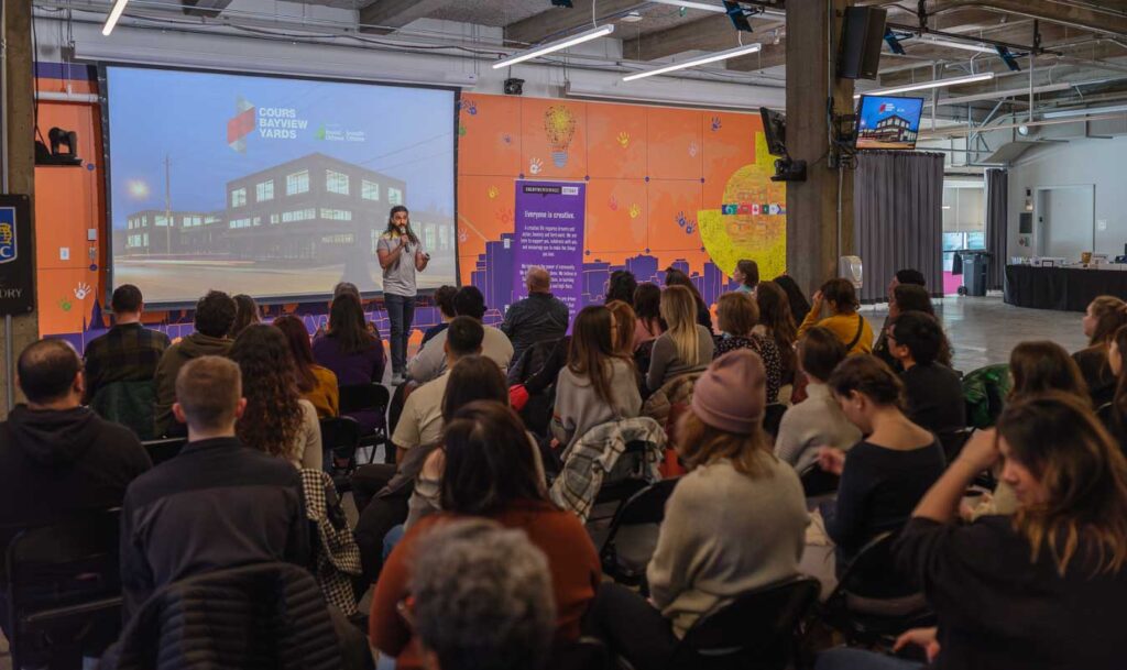 a crowd of people watching a speaker at Creative Mornings held at Bayview Yards