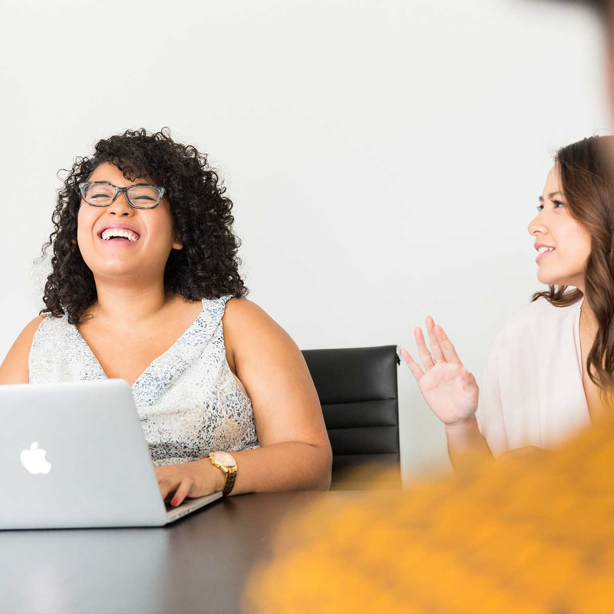 Two women smiling in a business meeting