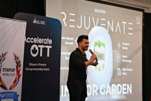 An entrepreneurs is on stage presenting through a microphone at an event. 