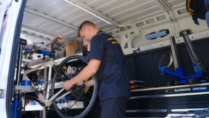 A person works on a bike in a mobile repair shop. 