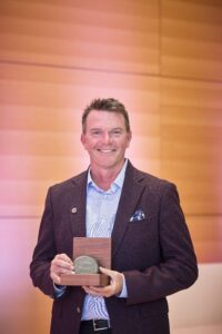 A photo of Nick Quain, holding the Trudeau Award 2025 . 