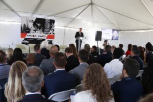 A speaker addresses a seated crowd in a presentation. 