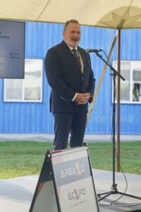 A man stands with hands folded presenting 