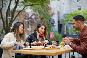 Three people site enjoying a meal on a patio table in Ottawa's downtown. 