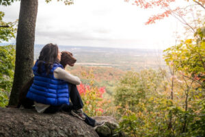 A woman sits with her dog overlooking a fall landscape in the Ottawa area, 
