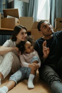 An image of a new family moving into a new space, smiling and taking a selfie. 