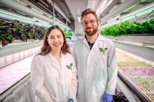 Growcer co-founders Corey Ellis and Alida Burke standing inside a vertical farming area. 